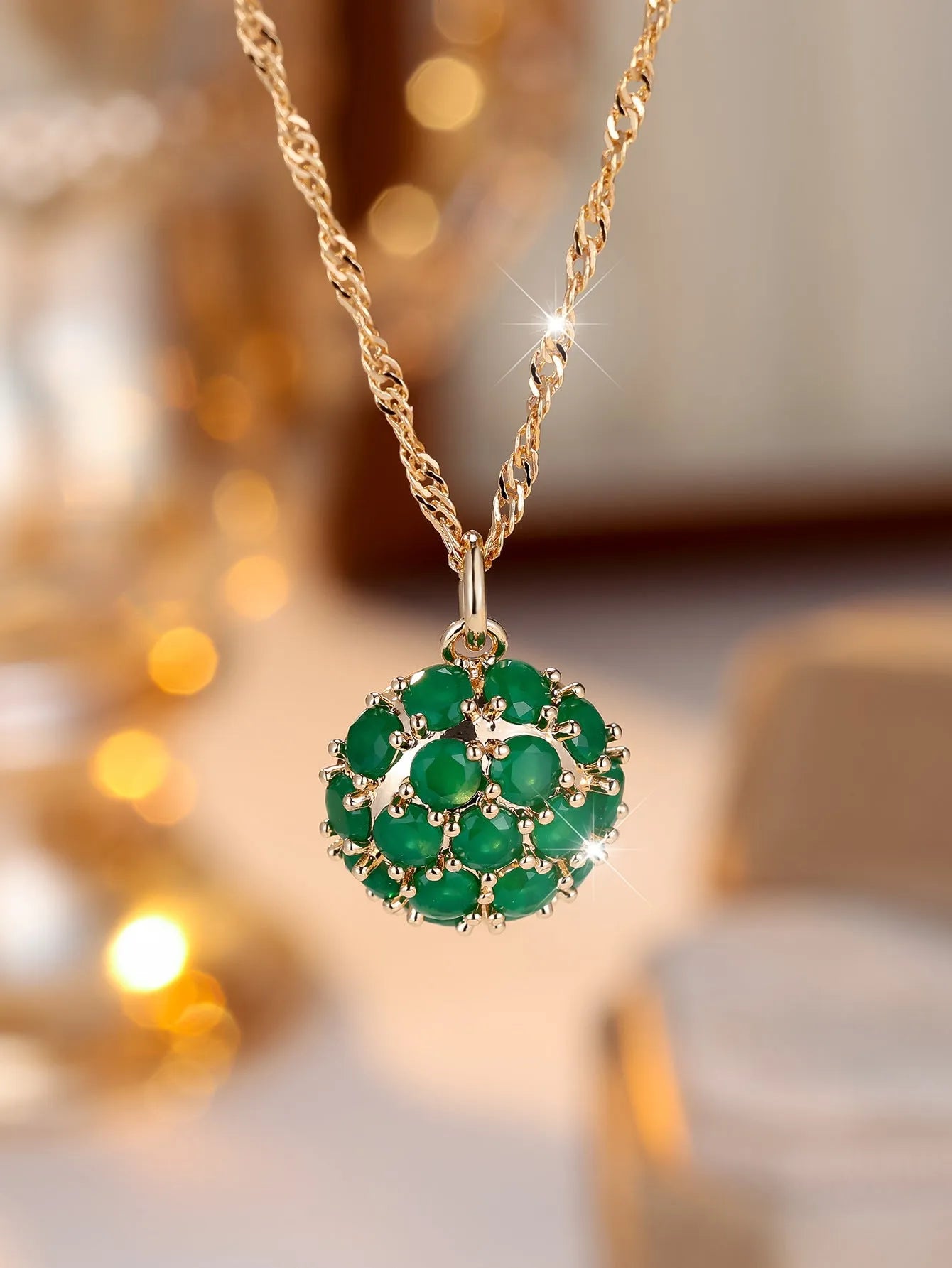 Geometric copper pendant necklace with round emerald and diamonds on an adjustable chain in champagne gold.