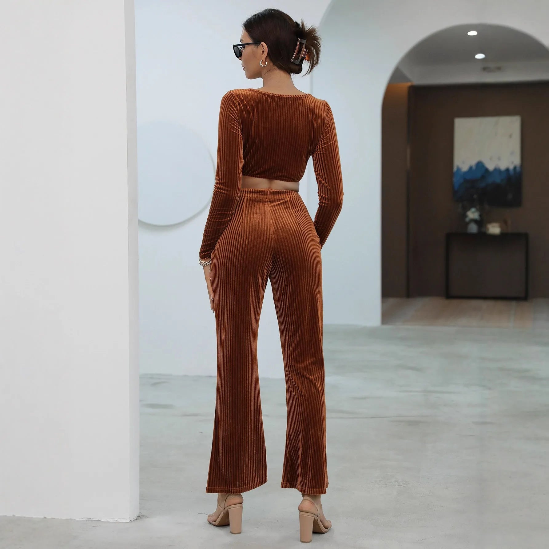 Caramel coloured long sleeve sweater and matching trousers lounge set on a hanger