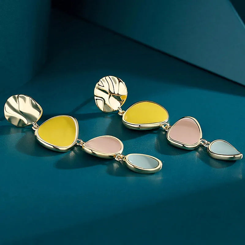 A pair of simple disc-shaped alloy earrings with a blended Morandi three-colour oil drip finish.