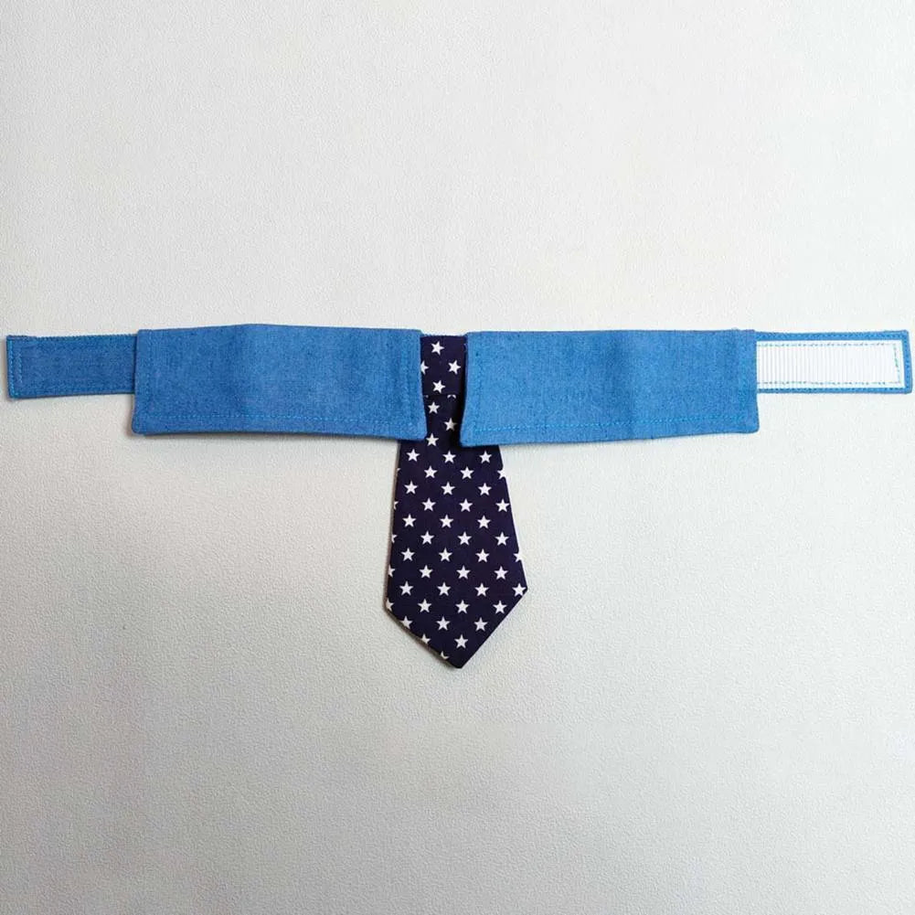 Blue denim dog collar styled as a necktie with white star pattern, showing fastener tape adjustment.