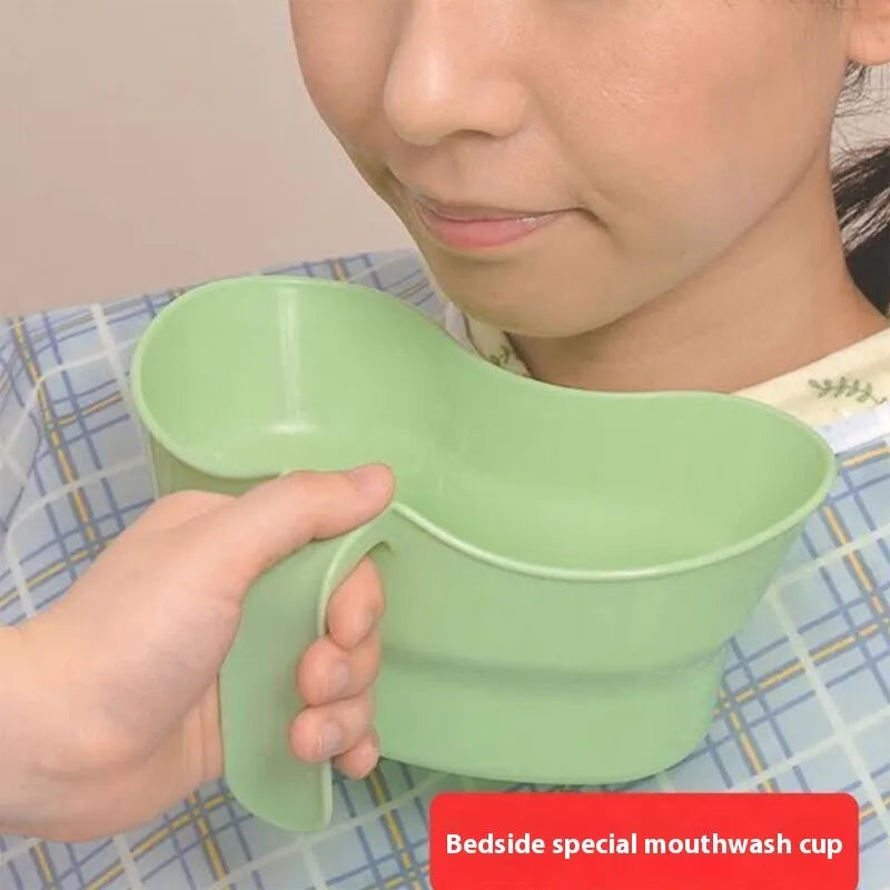 Green plastic nursing cup with an angled spout for bedridden patient drinking.
