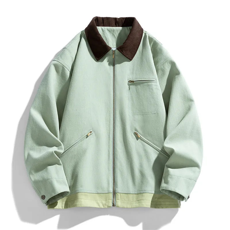 Man wearing a mint green loose-fit retro workwear jacket with dark contrast lapels and side seam pockets.