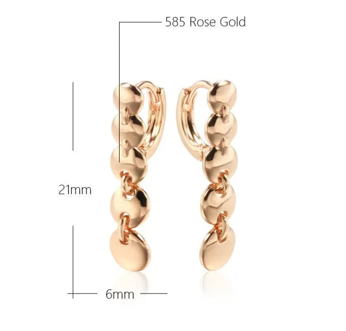 A pair of long, round, gold-toned retro earrings with a woven copper design.