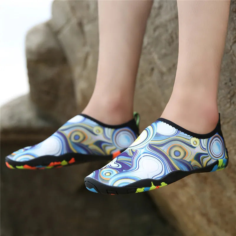 Blue Lycra beach wading shoes with EVA midsole on a sandy beach