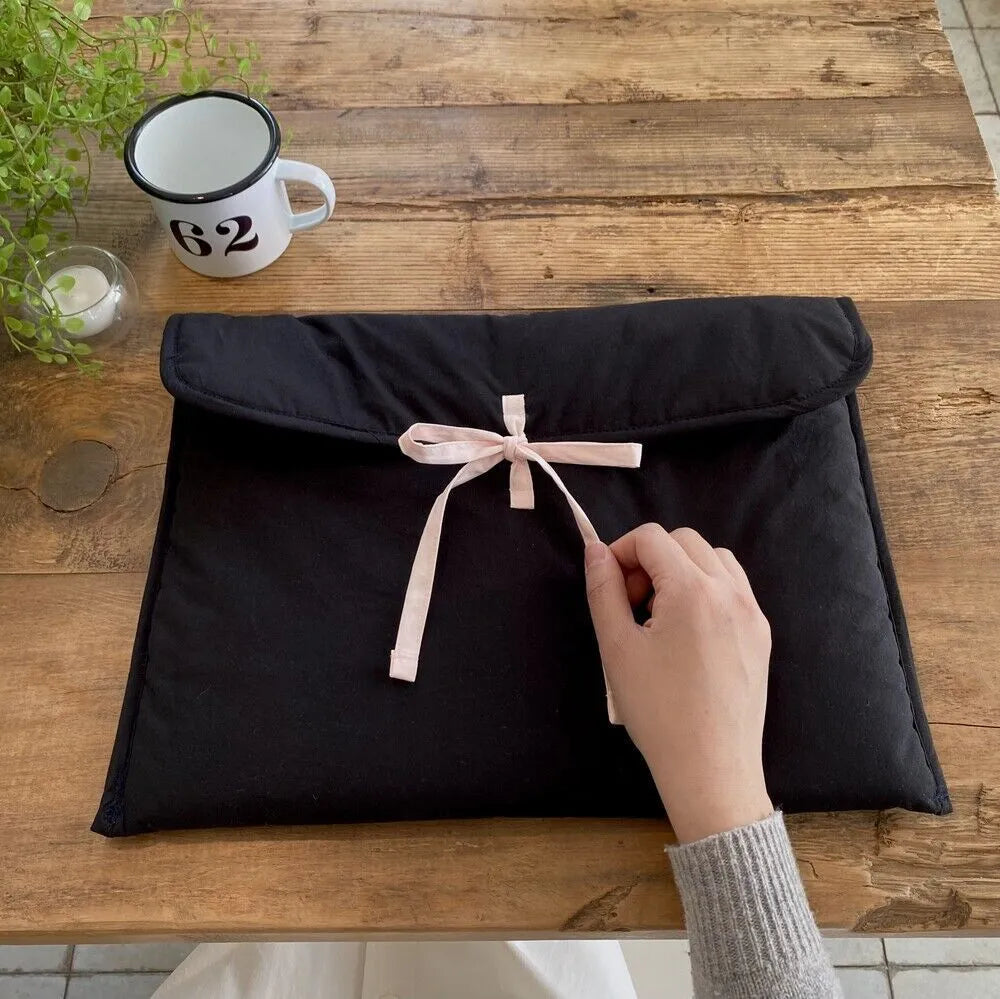 Black and white quilted women's laptop bag with a ballet bow and striped pattern.