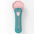 Green and pink pet food squeezer scoop dispensing a treat for a cat or dog.