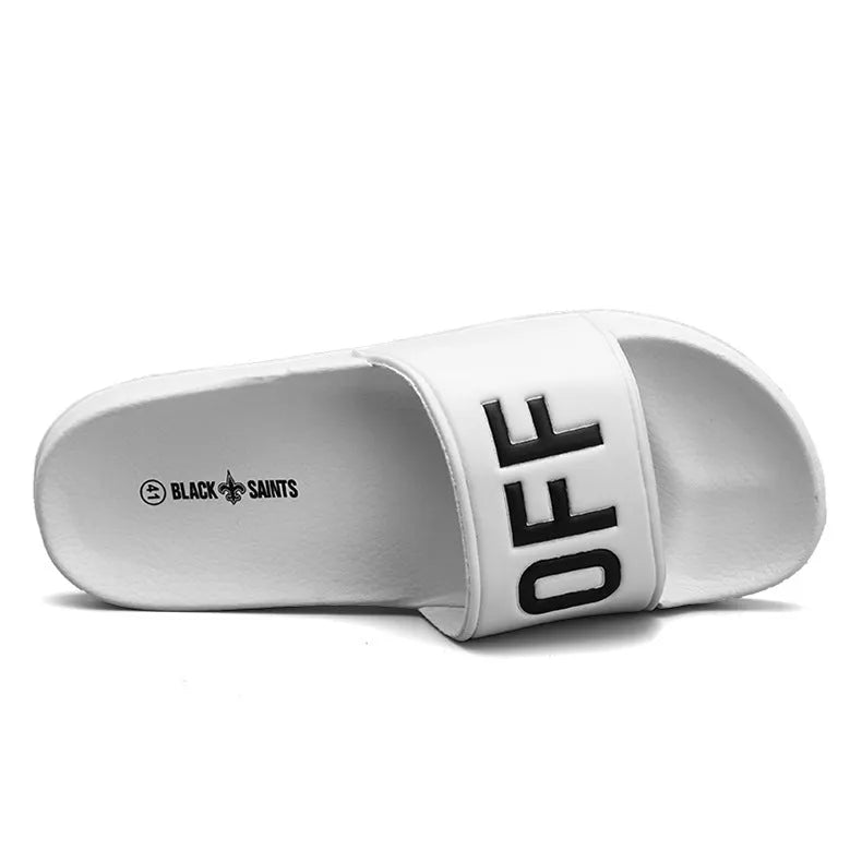Men's black and white open-toe slippers with a textured rubber sole on a plain background