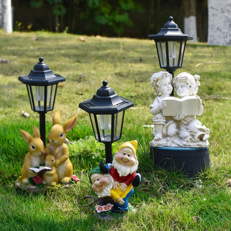 Solar hexagonal garden lamp with decorative resin figurine on plastic base for outdoor pathway lighting