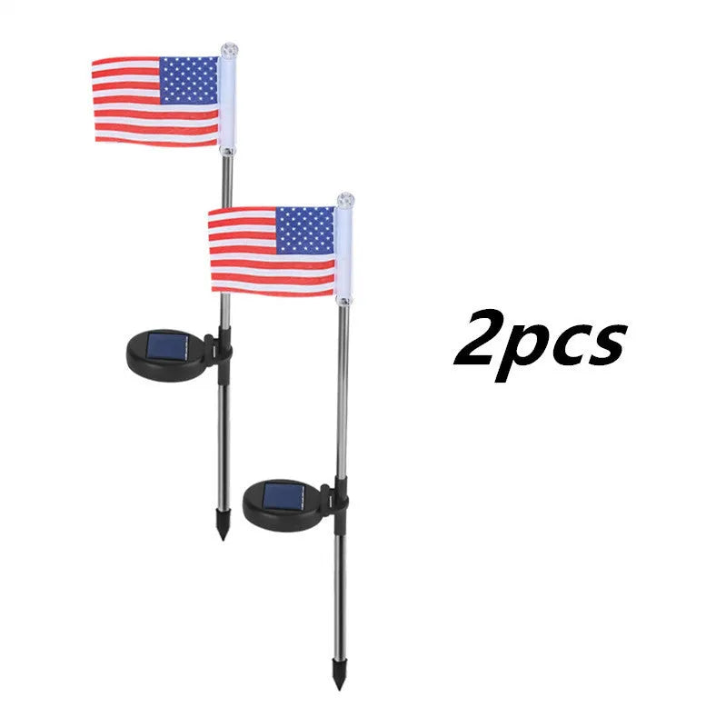 Solar-powered garden flag light displaying either American or British flag design with stainless steel pole and solar panel