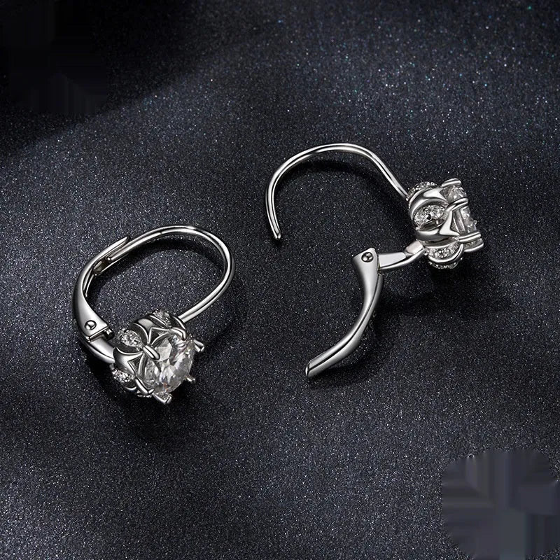 A pair of sterling silver flower bud design ear clips with white gold plating and moissanite stones.