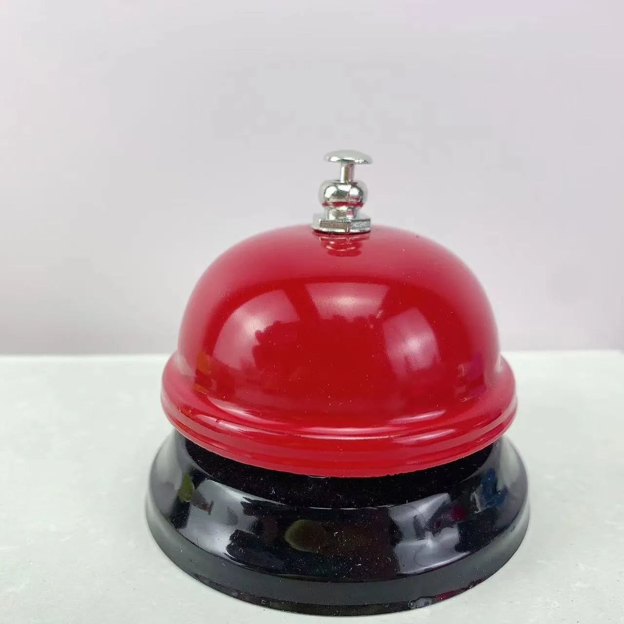 A multi-colour iron hand bell for games, classrooms, or restaurant service.