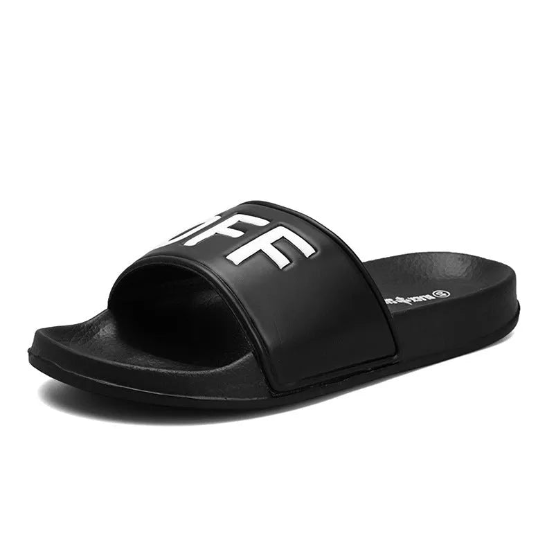 Men's black and white open-toe slippers with a textured rubber sole on a plain background