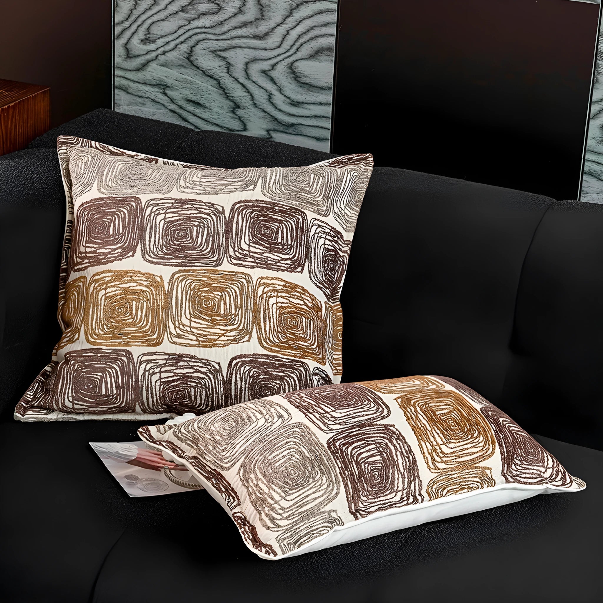 Cream and coffee abstract coil pattern pillow cover on a grey sofa