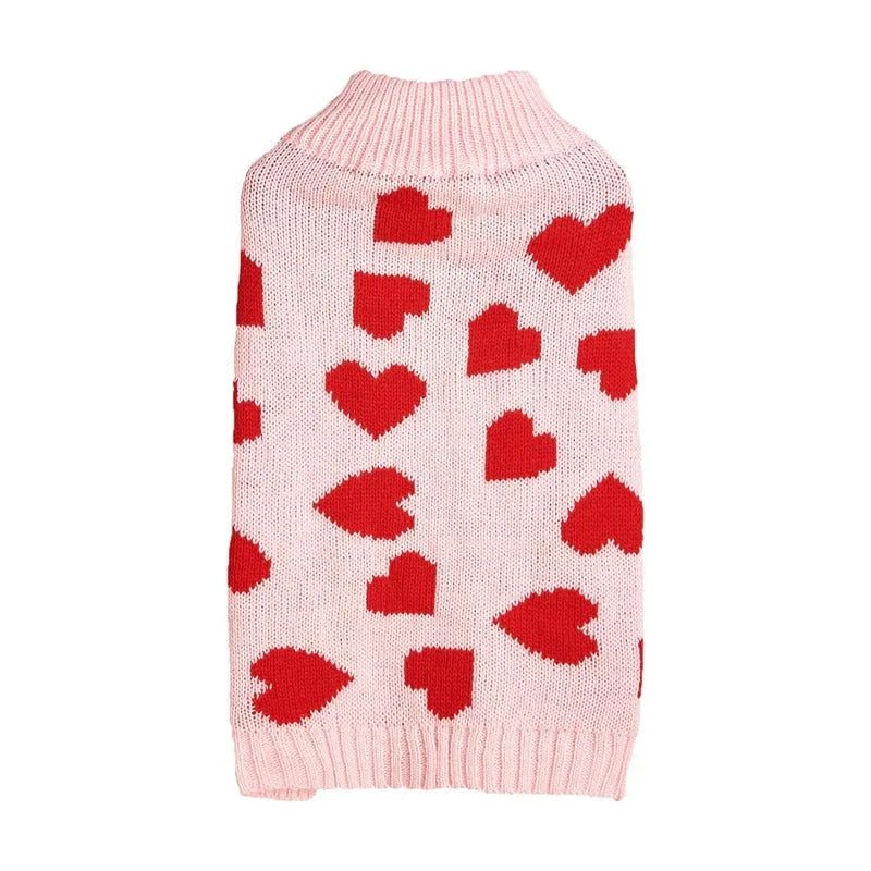 Small dog wearing a pink acrylic sweater with a bow and love heart design in ins style