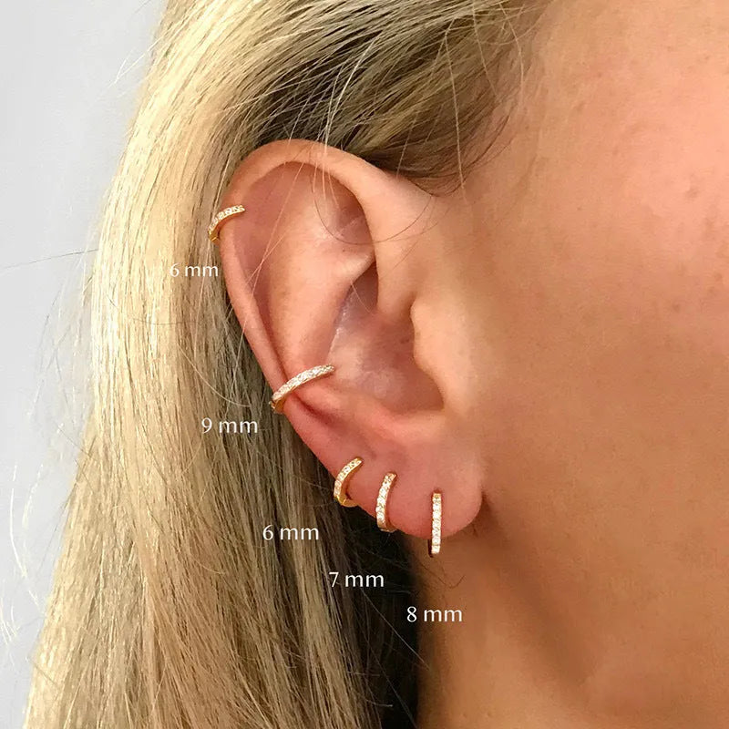 Set of gold, rose gold, and silver perforated circle stud earrings in multiple sizes on a flat surface.