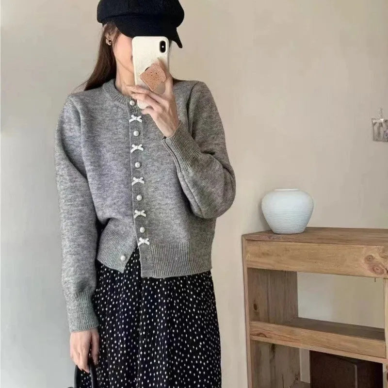 Women's solid colour cardigan sweater with bow and pearl button design in medium thickness fabric