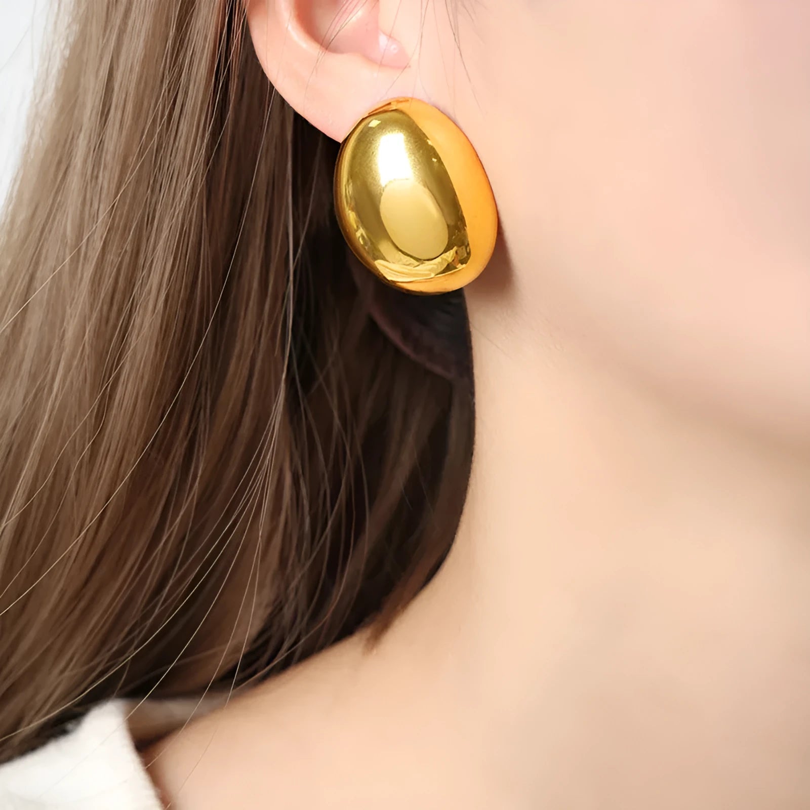 Geometric women's earrings with a gold glazed finish and simple line designs on a white background.