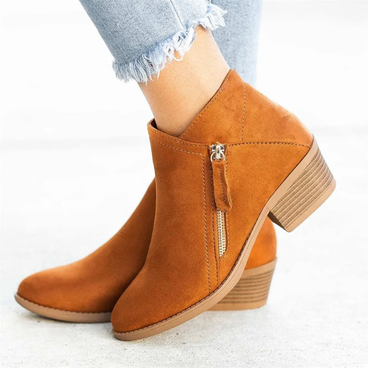 Blue Dr Martens women's suede ankle boots with a side zip and chunky heel on a white background.