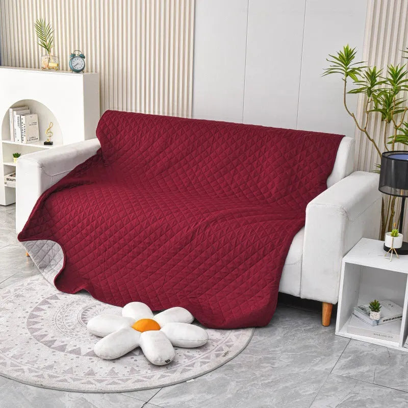 Reversible dog blanket sofa cover in burgundy colour protecting a leather couch from pet damage