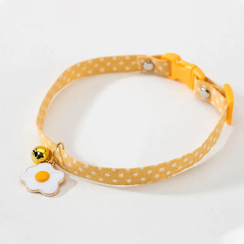 Adjustable green cat collar with a metal bell and a matching bow tie for small pets.