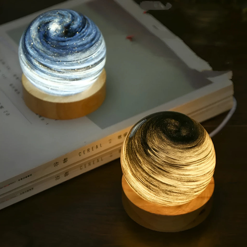 Planet night light with spherical design on base, USB cable connected, showing adjustable three-colour lighting