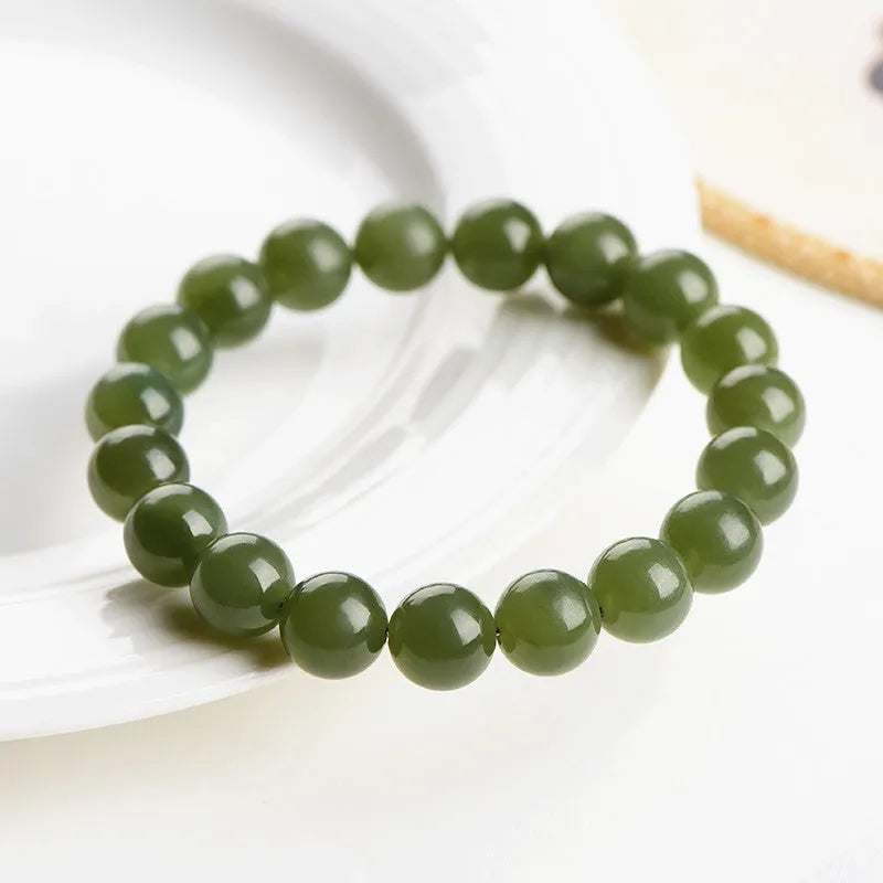Polished Hetian jade bead bracelet in clear ice-like colours on a white background.