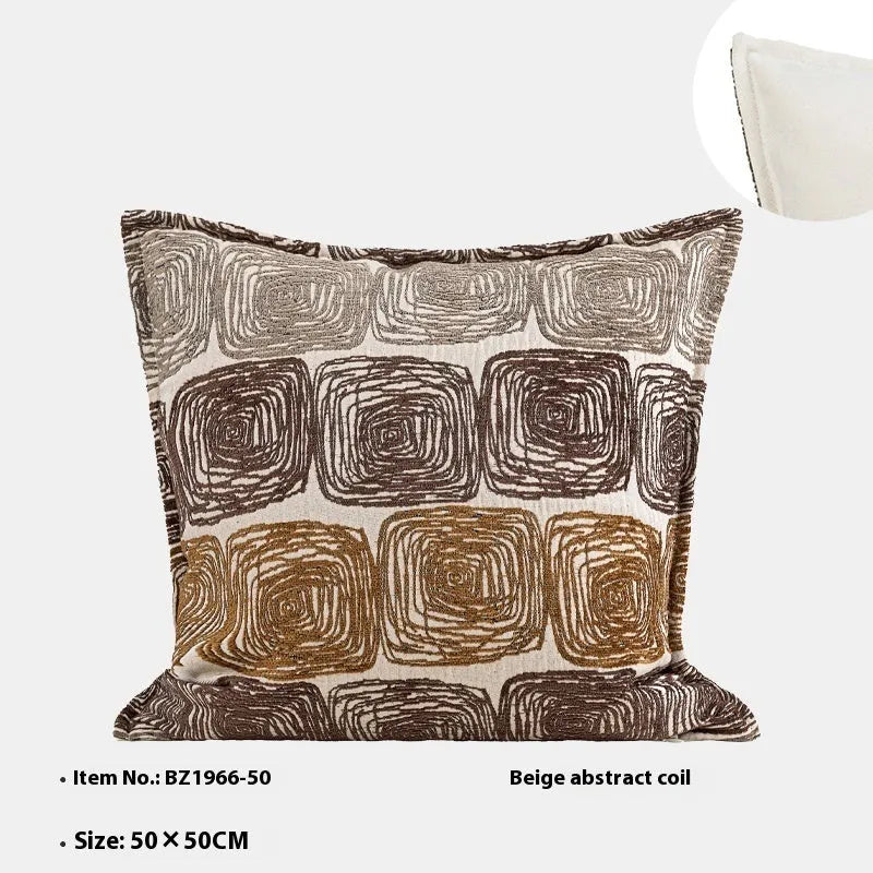 Cream and coffee abstract coil pattern pillow cover on a grey sofa