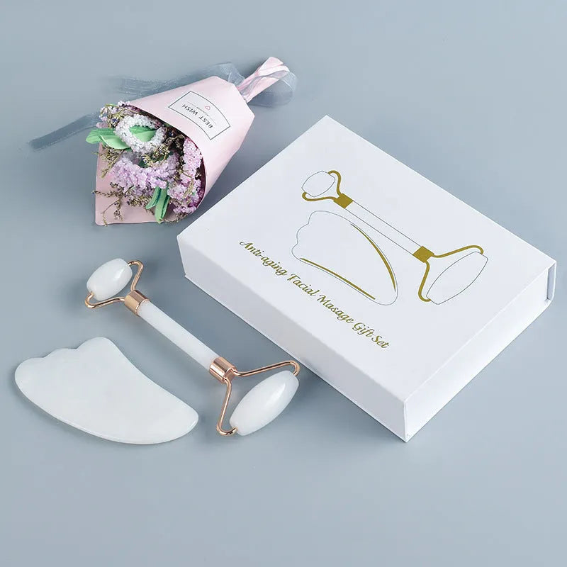White jade double-headed facial roller and gua sha scraping tool set with a wooden storage board.