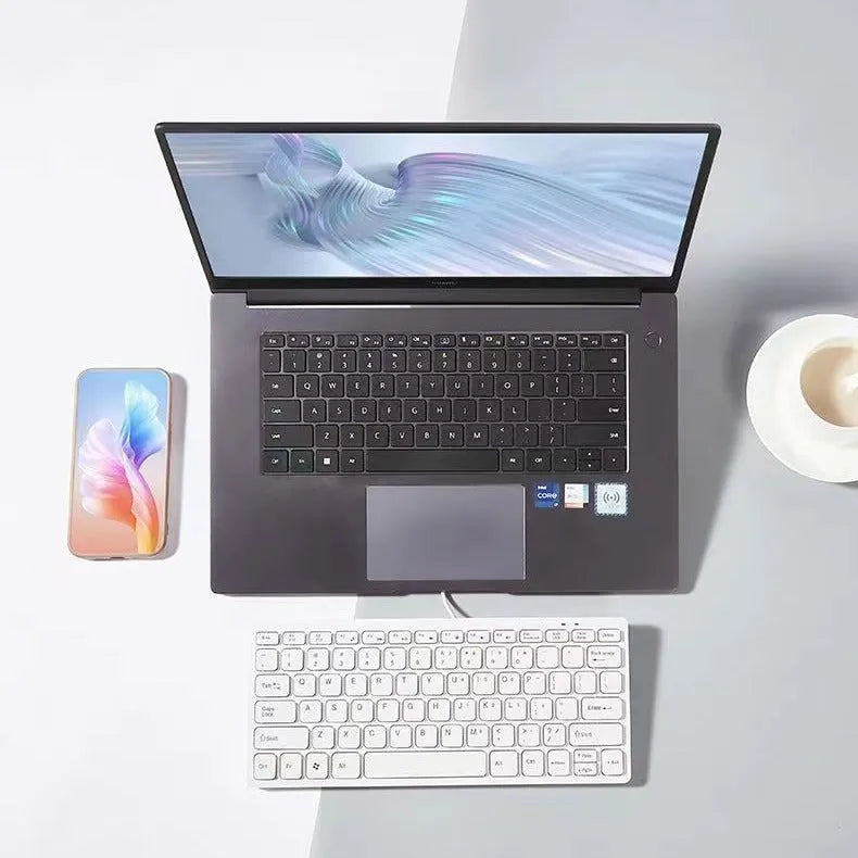 Compact USB wired mini keyboard in black, white, pink, or blue on a desk.