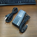 Black 65W USB-C laptop power adapter with a set of international plug cords for UK, US, EU, AU and SA sockets.