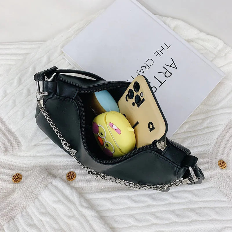 Women's black PU leather crossbody bag with butterfly chain shoulder strap showing internal phone pocket