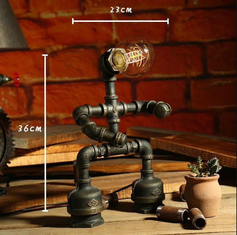 Green bronze vintage industrial iron pipe desk lamp on a wooden table.