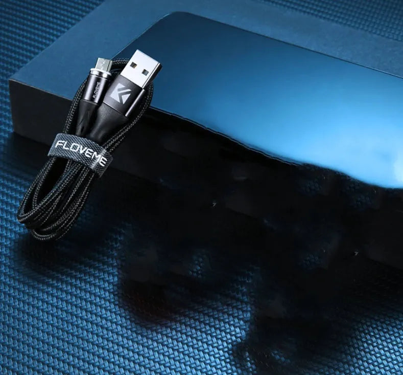 Black magnetic USB charging cable with illuminated side light on connector, next to smartphone.
