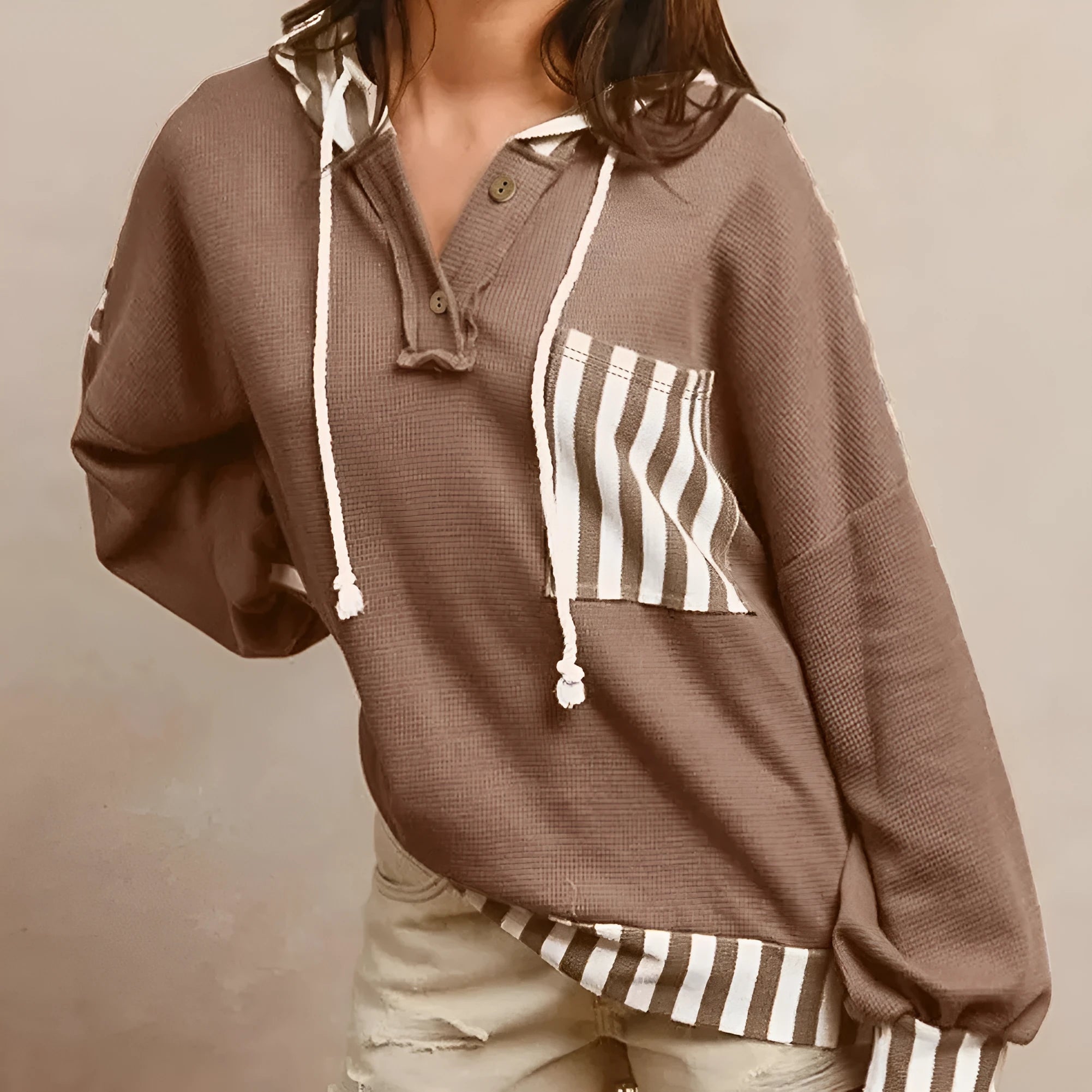 Straw yellow hoodie with waffle texture and striped patchwork design, featuring a button neck and drawstring hood.