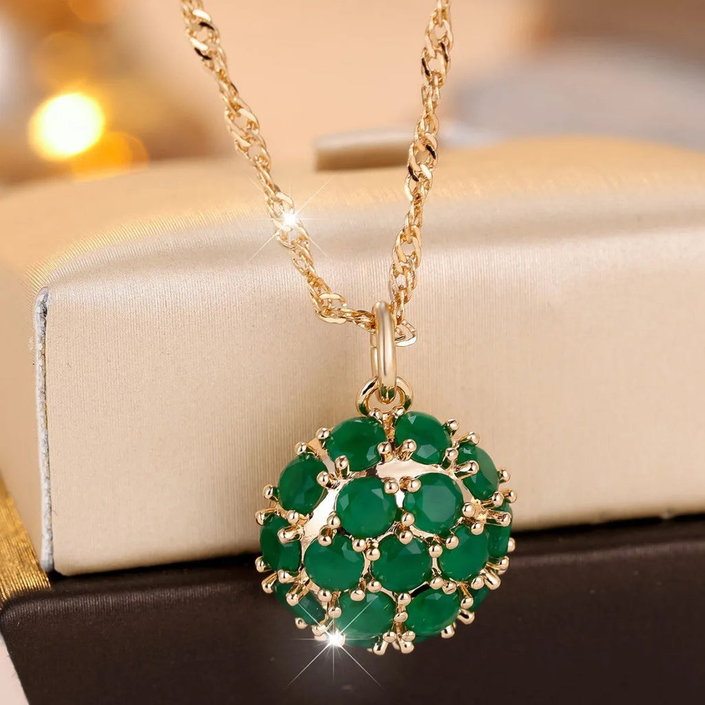 Geometric copper pendant necklace with round emerald and diamonds on an adjustable chain in champagne gold.