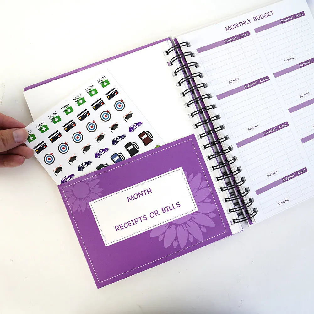 A5 purple budget notebook with coil binding, stickers, pen, and paper clips for financial planning