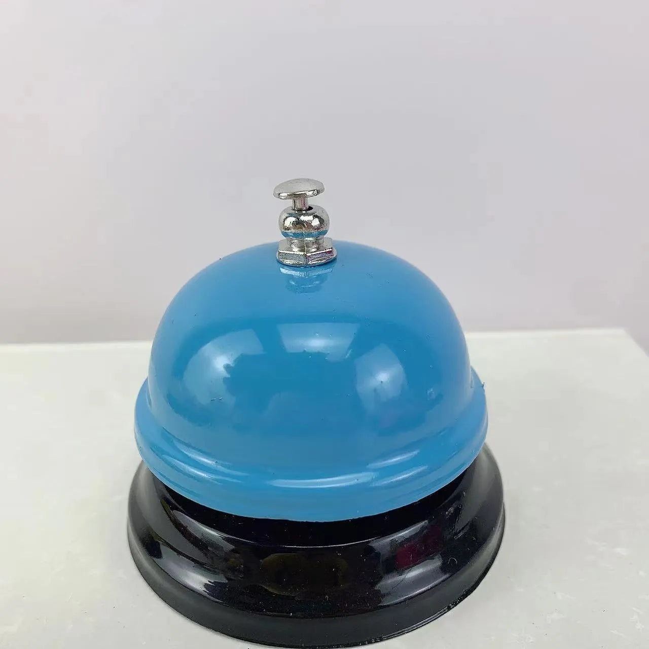 A multi-colour iron hand bell for games, classrooms, or restaurant service.