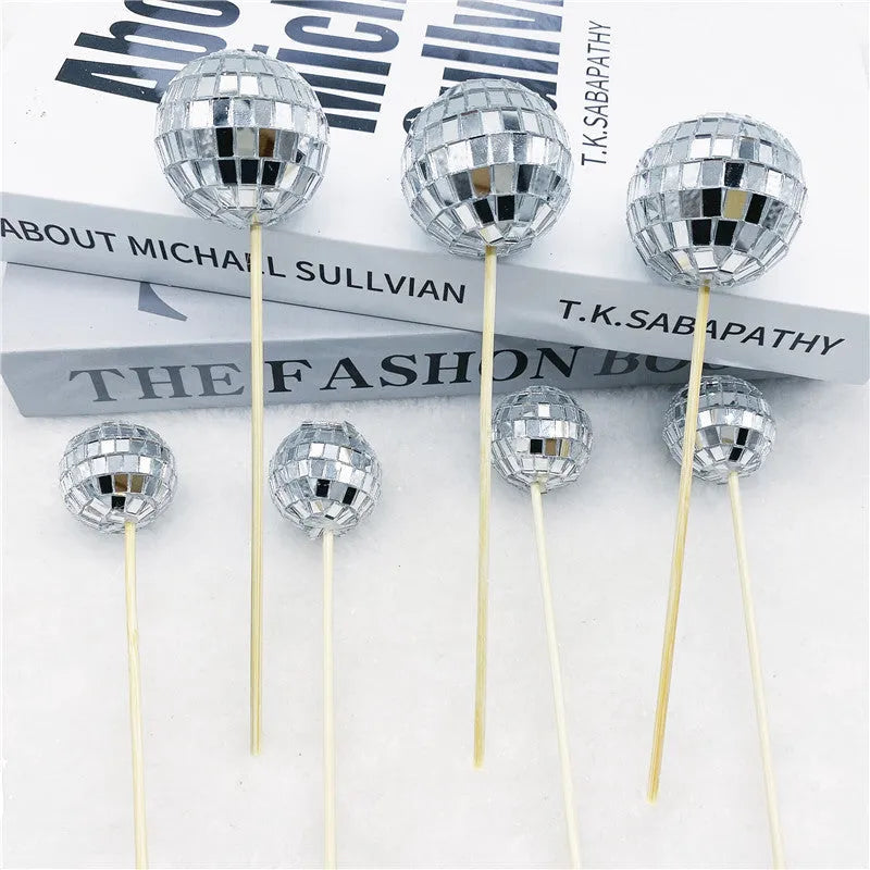 Glass mirror ball cake decoration on a wooden stick in various sizes for birthday and party cakes.