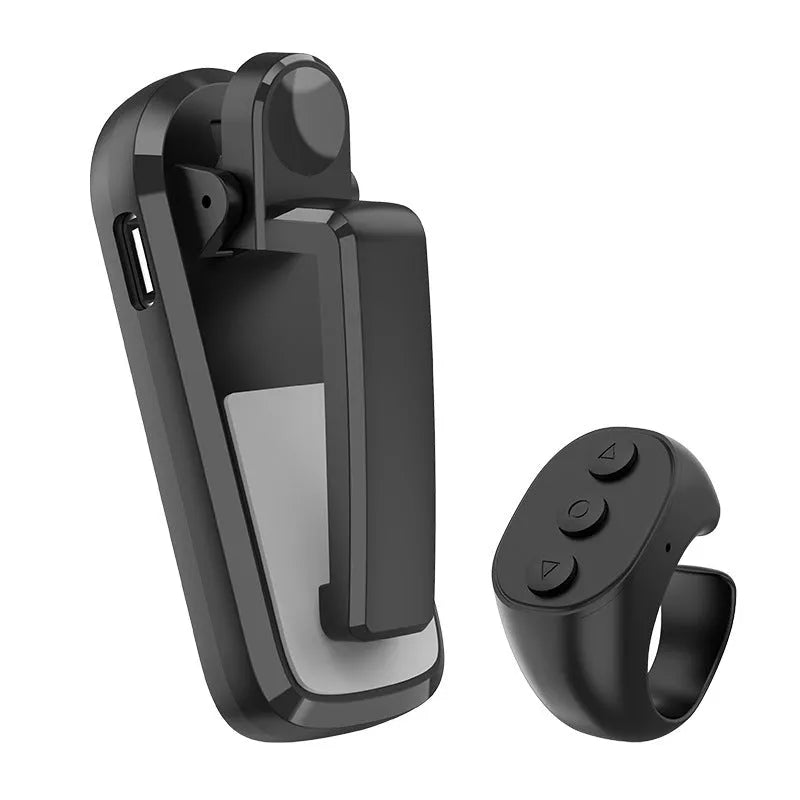 A black wireless page turner remote control and a separate clicker unit on a wooden desk.