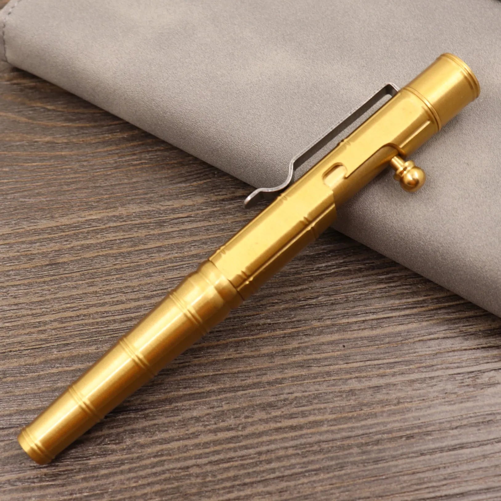 Retro brass tactical pen with cylindrical barrel and six-ring grip, shown with press mechanism extended