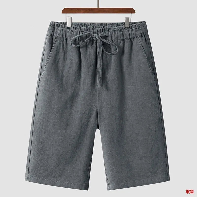Men's beige linen casual shorts with a loose fit and cropped length on a plain background.