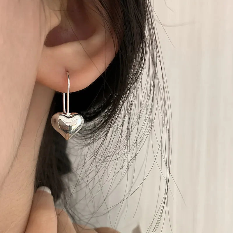 Three-dimensional glossy heart-shaped earrings in silver colour made from copper with white gold finish, Korean style for women