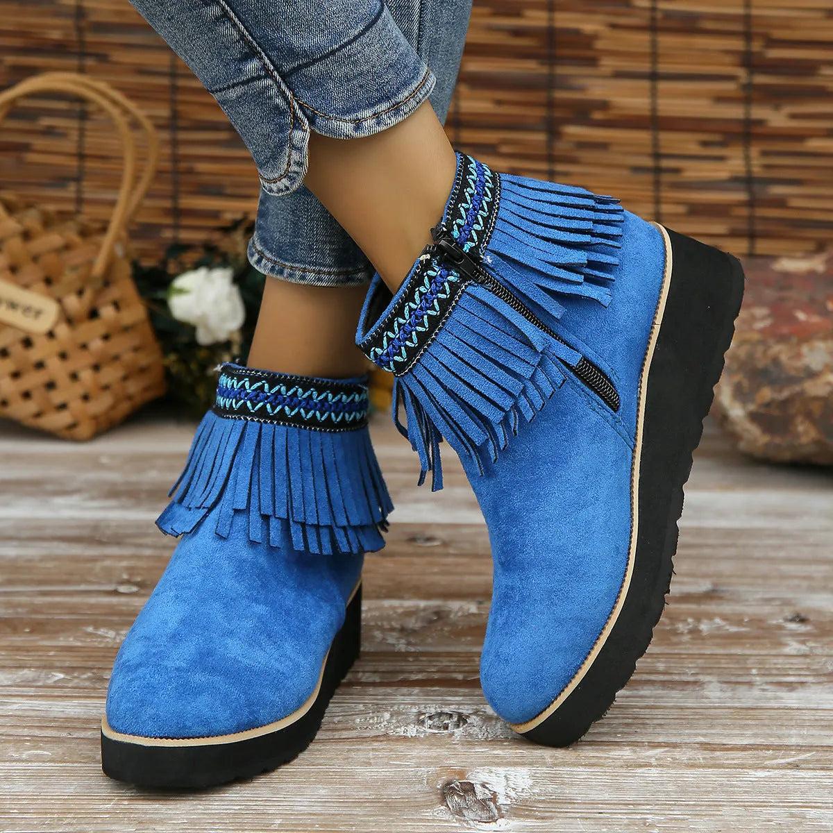 Women's black suede wedge ankle boot with side zip and tassel detail on a thick rubber platform sole.