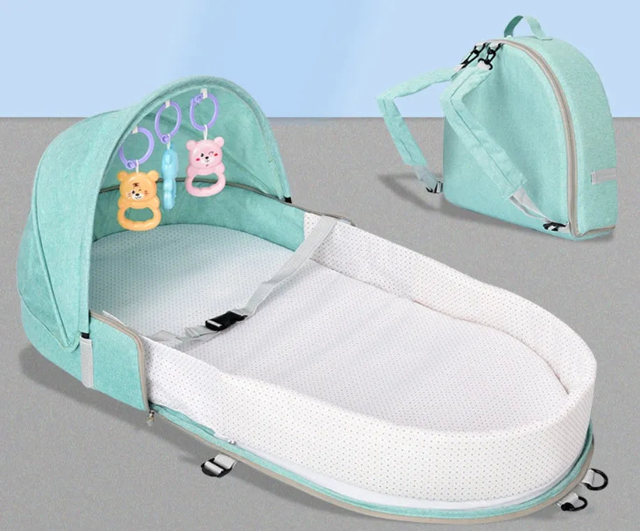 Portable foldable baby anti-mosquito isolation bed with grey cotton linen fabric, open on a grassy area