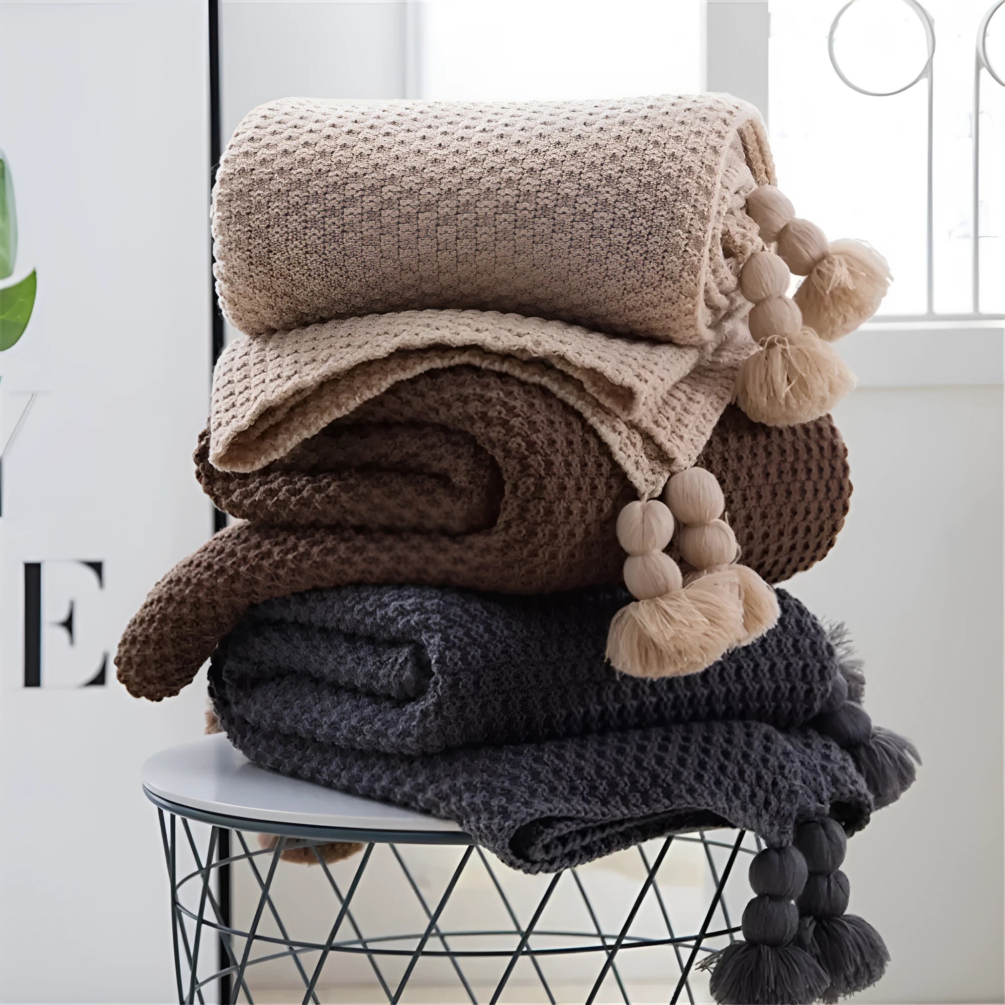 Nordic fringed knit ball acrylic blanket in beige colour on a sofa