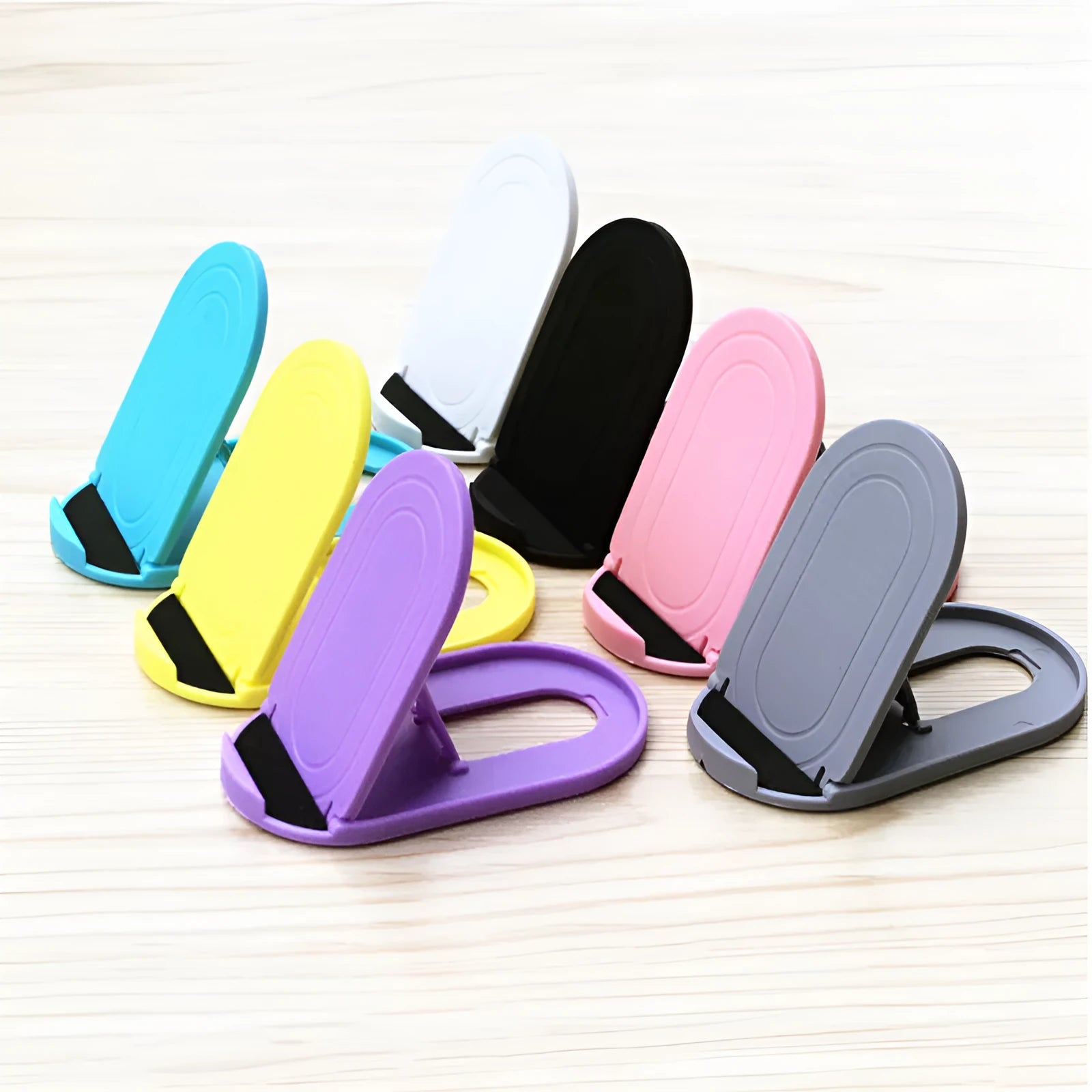 Plastic lazy bracket mobile phone stand shown in one of six available colours: black, blue, grey, pink, white, or yellow.