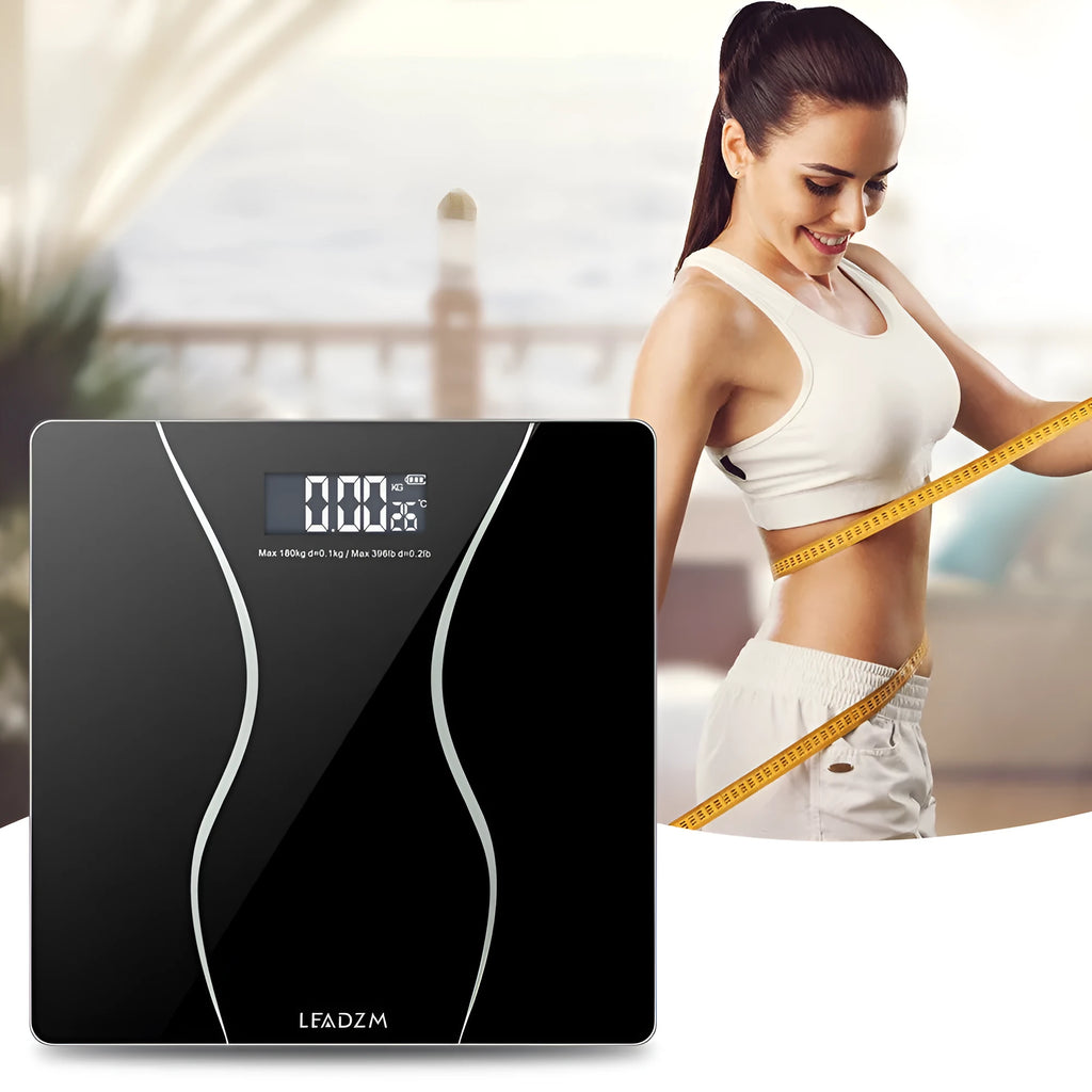 Black electronic digital bathroom scale on a bathroom floor, showing a maximum weight capacity of 180kg.