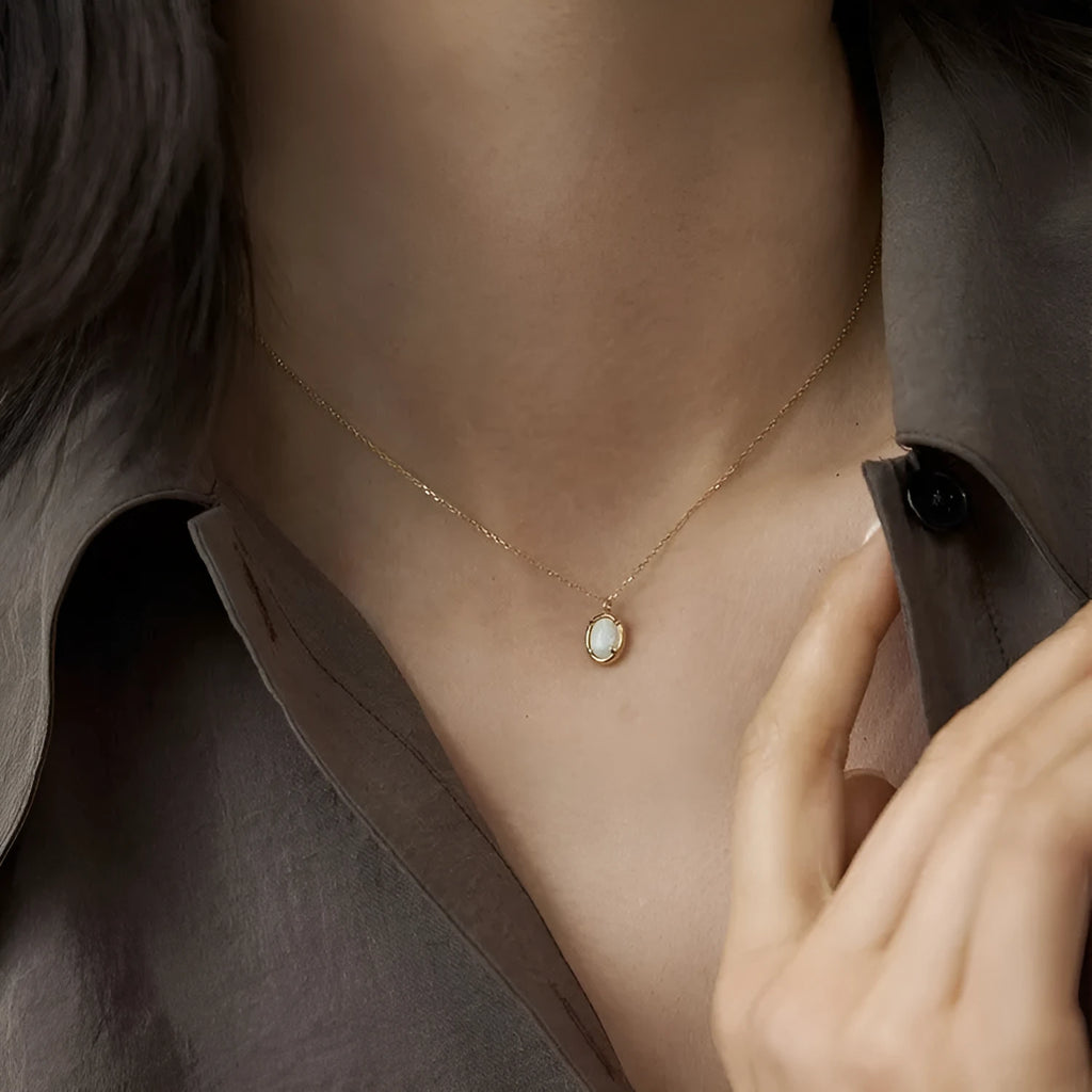 Oval jelly opal pendant necklace on a silver chain with choice of gold or white gold finish.