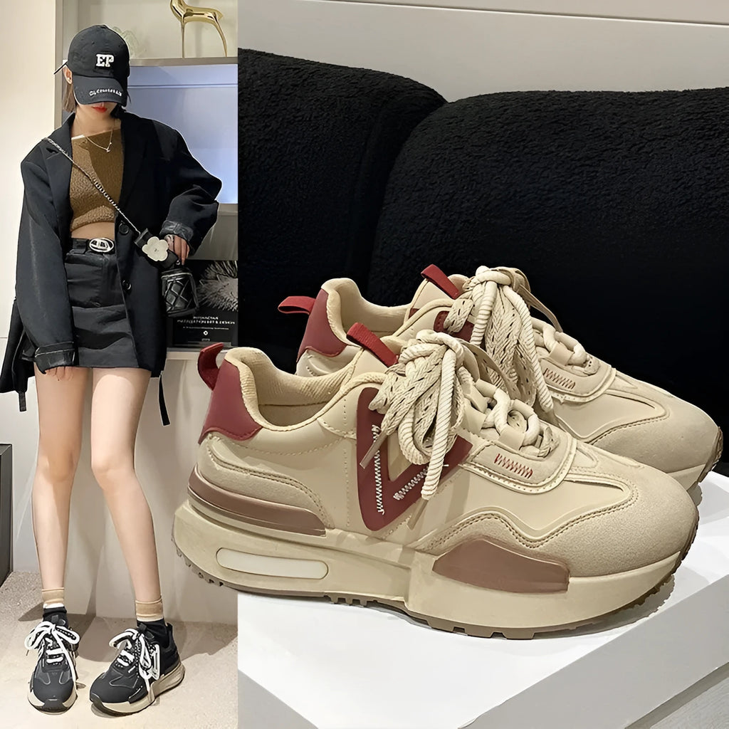 Women's black platform trainers with round toe and lace-up design, showing rubber sole