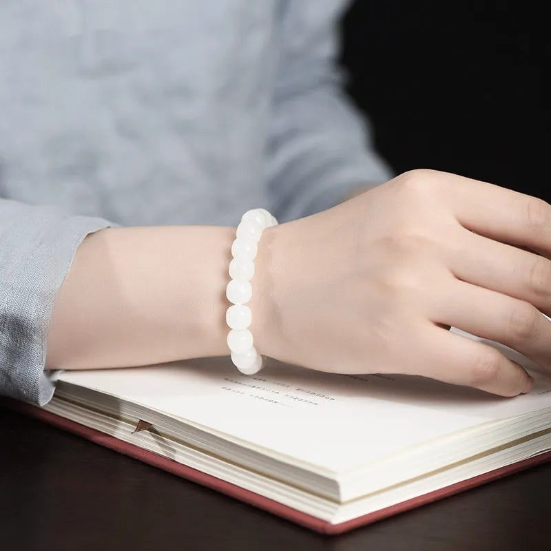 White Hetian jade barrel bead bracelet laid flat, showing unisex casual design.